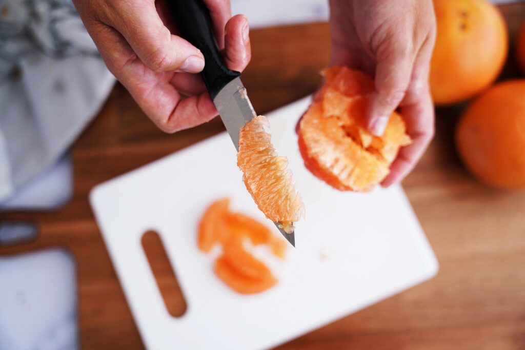 Showing grapefruit segment on knife