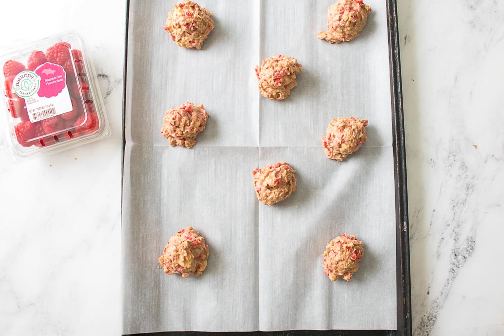 Oatmeal raspberry cookie dough on a parchment-lined cookie sheet