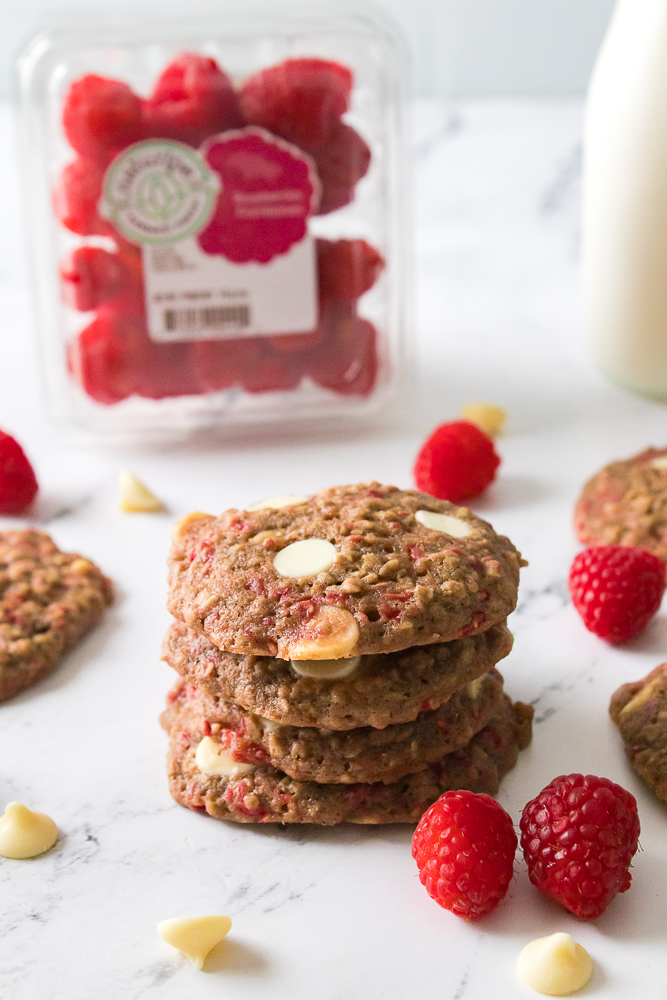 oatmeal raspberry cookies stacked with Naturipe raspberry package in background