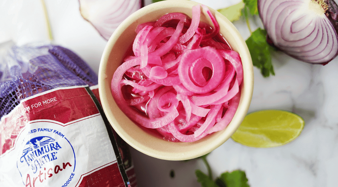 Pickled Red Onions in bowl with bag of onions