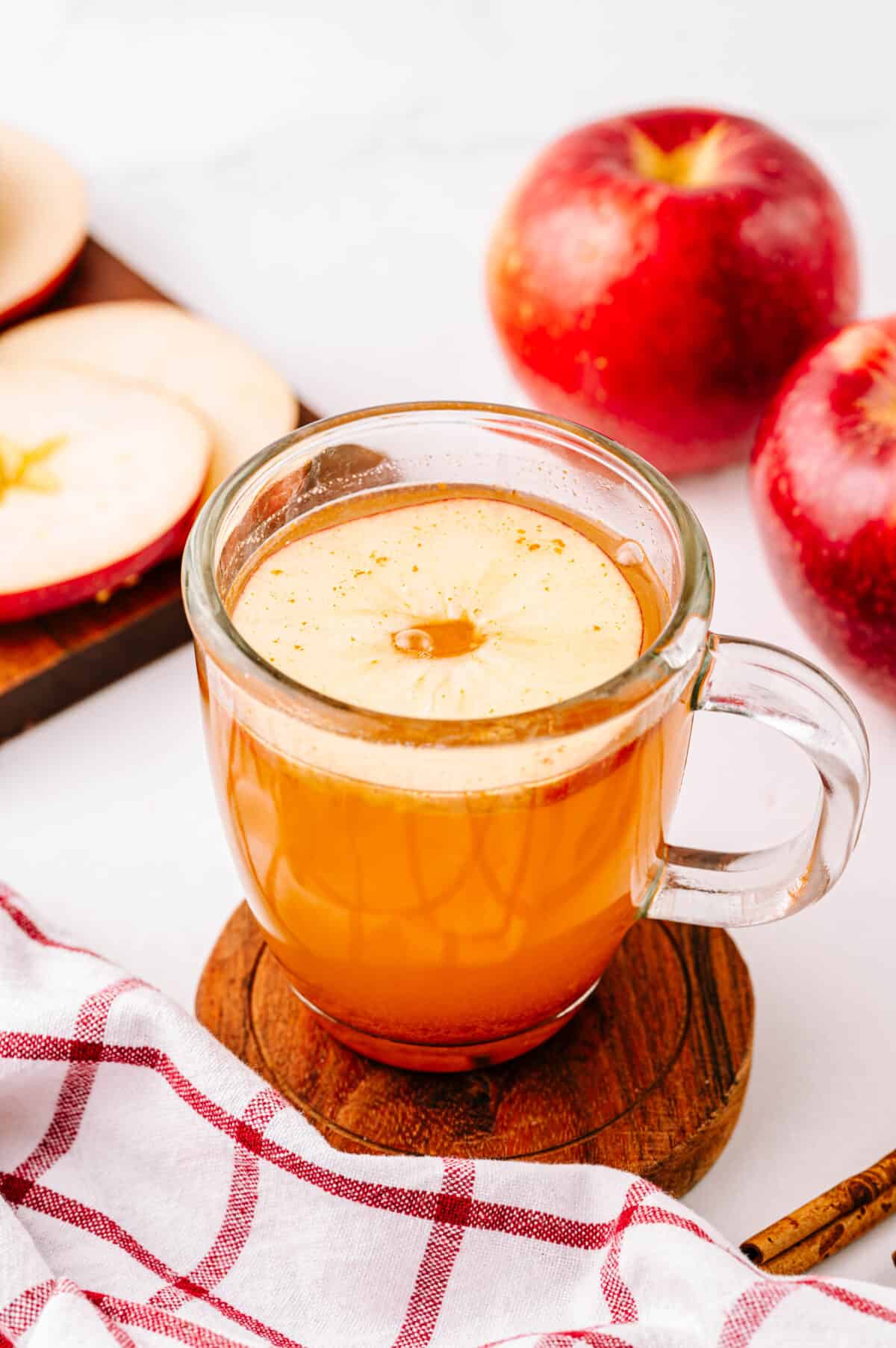 apple cider hot toddy with apple ring in clear mug