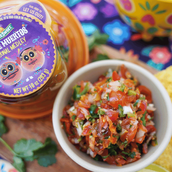 Overview of Salsa in a bowl with NatureSweet® Dia de los Muertos Constellation Tomato packaging