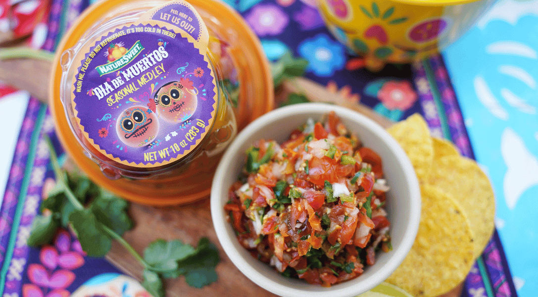 Overview of Salsa in a bowl with NatureSweet® Dia de los Muertos Constellation Tomato packaging