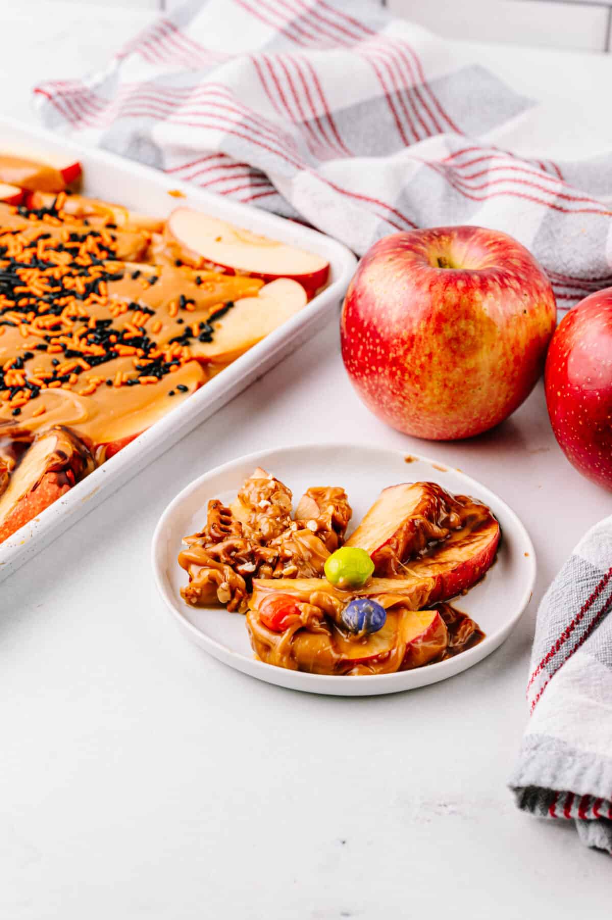 plate of caramel apple slices with SweeTango® apples in the background