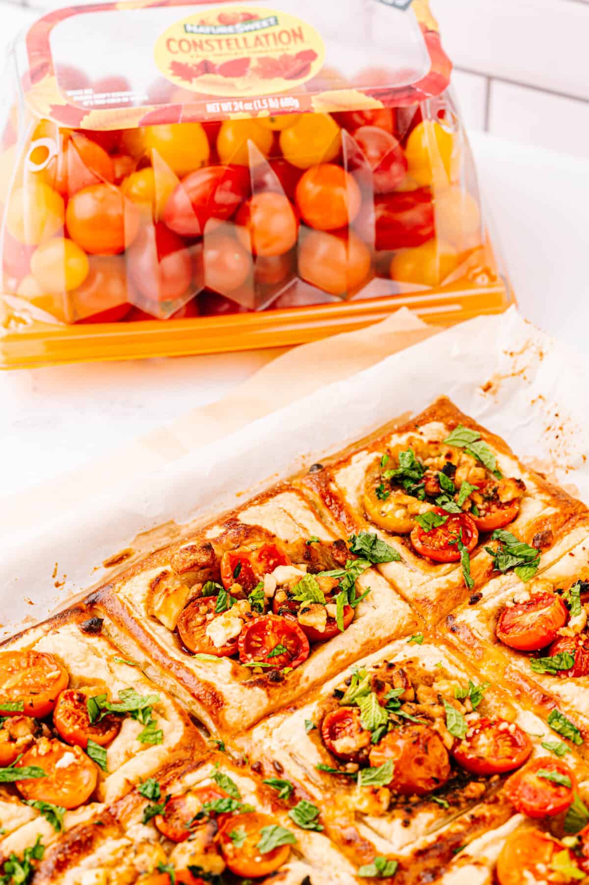 close up vertical shot of tomato tarts baked on parchment paper