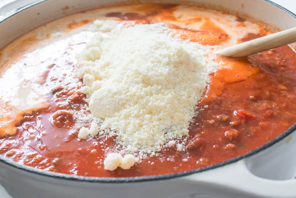 grated cheese added to pot with crushed tomatoes and milk