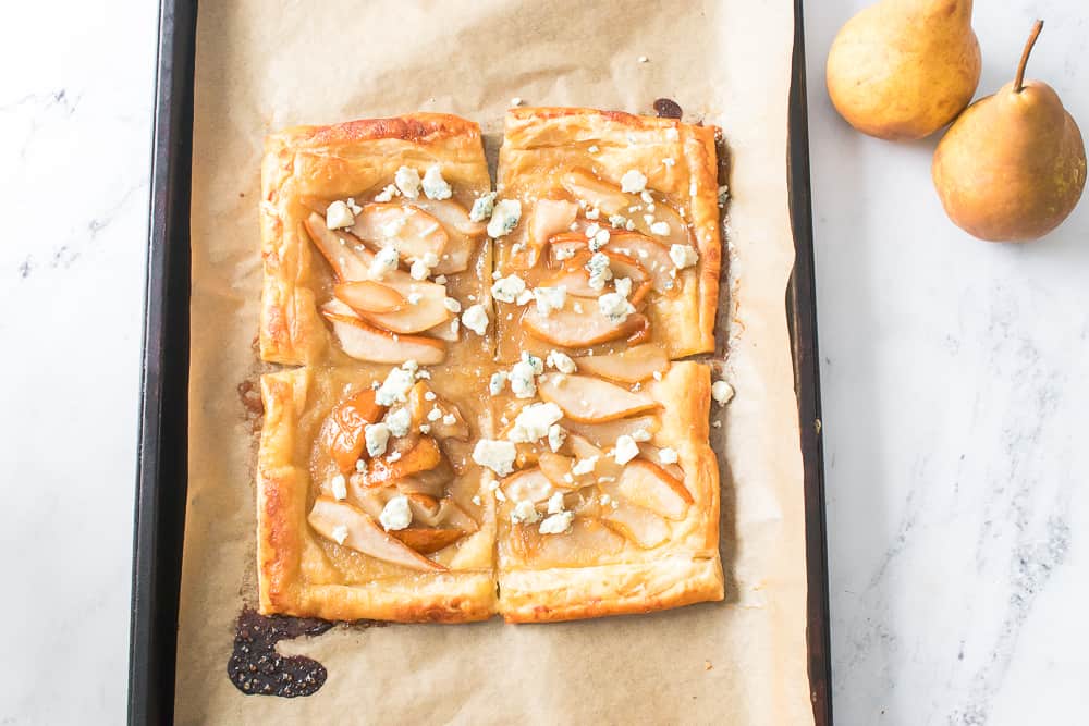 overhead shot of baked puff pastry with caramelized pears, blue cheese and toasted walnuts