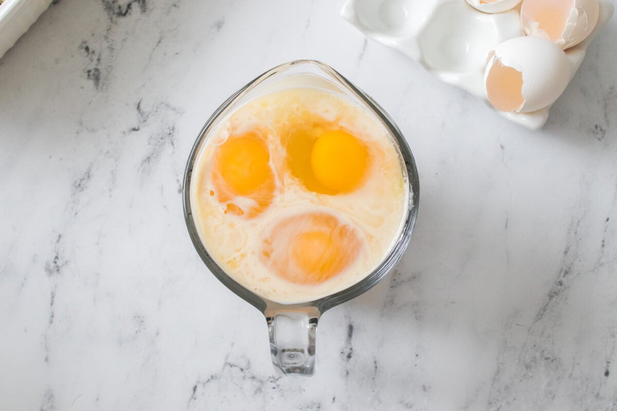 evaporated milk and three eggs in measuring cup