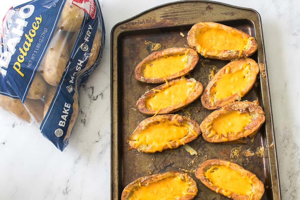 potato skins loaded with cheese on a sheet pan