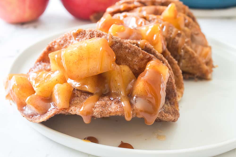 close up shot of apple pipe tacos with caramel sauce drizzled over apples