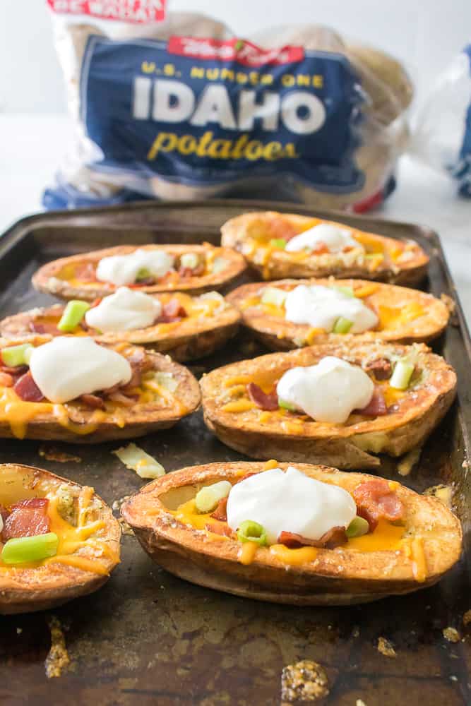 vertical image of loaded potato skins on a sheet pan 