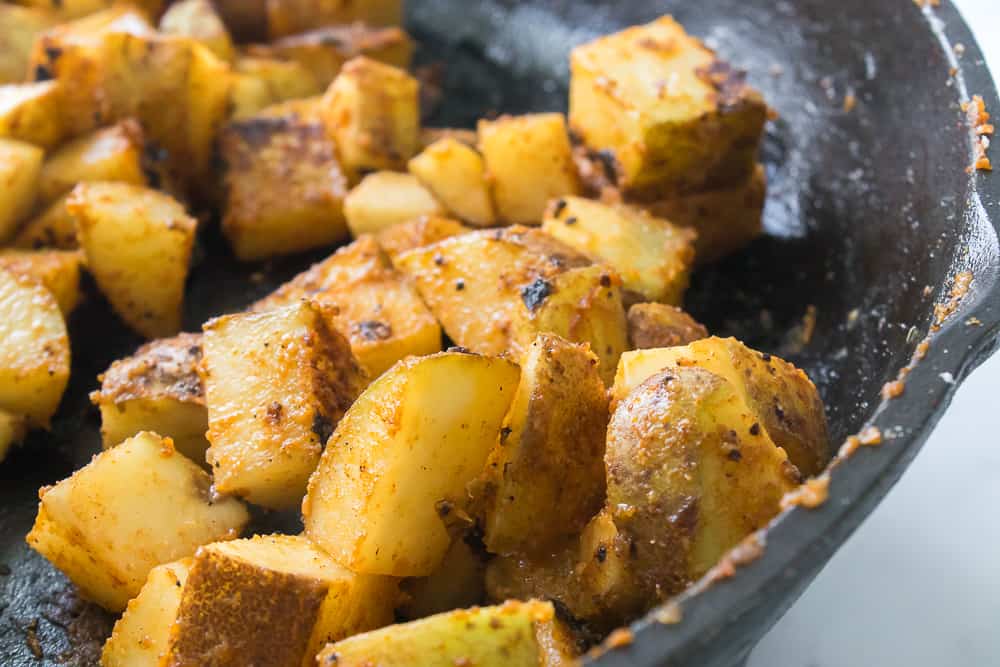 close up shot of roasted potatoes in the cast iron skillet