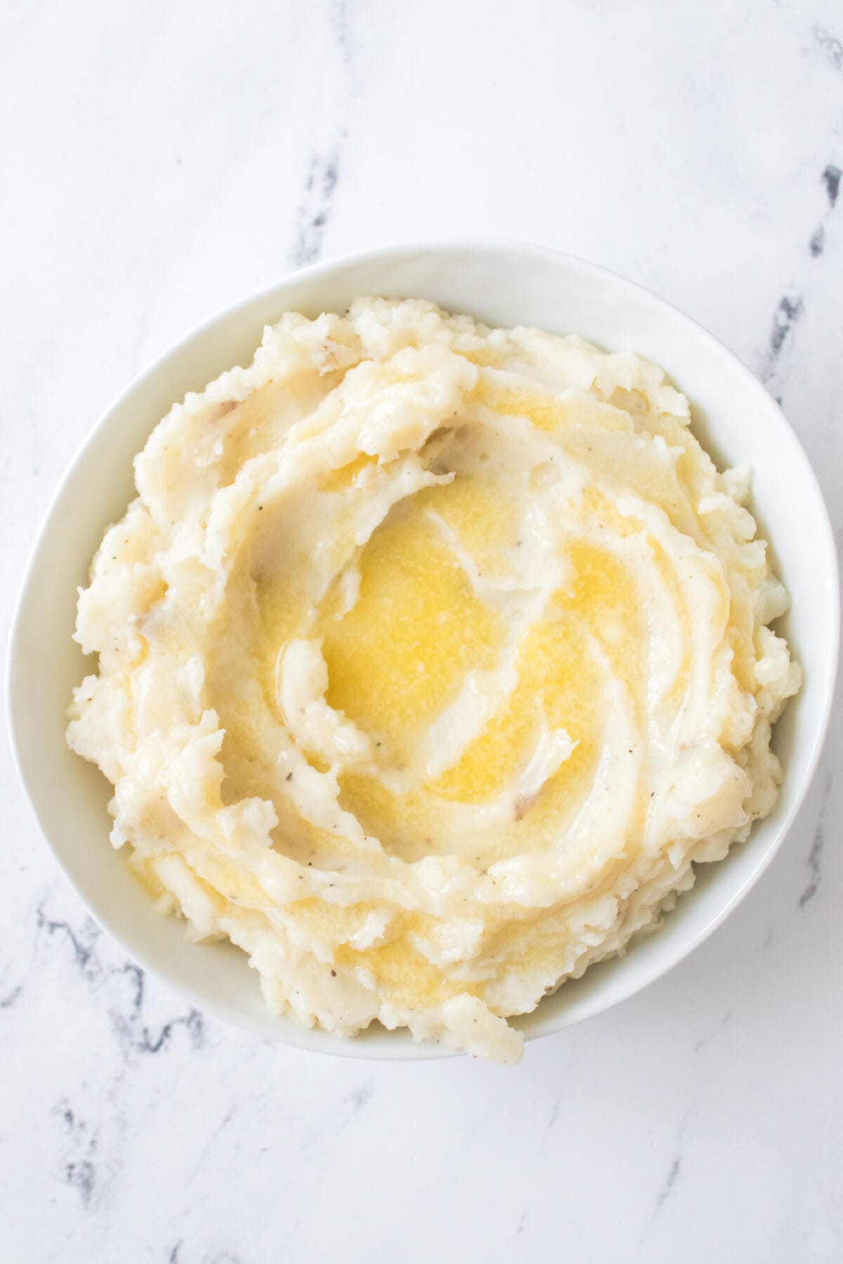 vertical image of mashed potatoes in a bowl