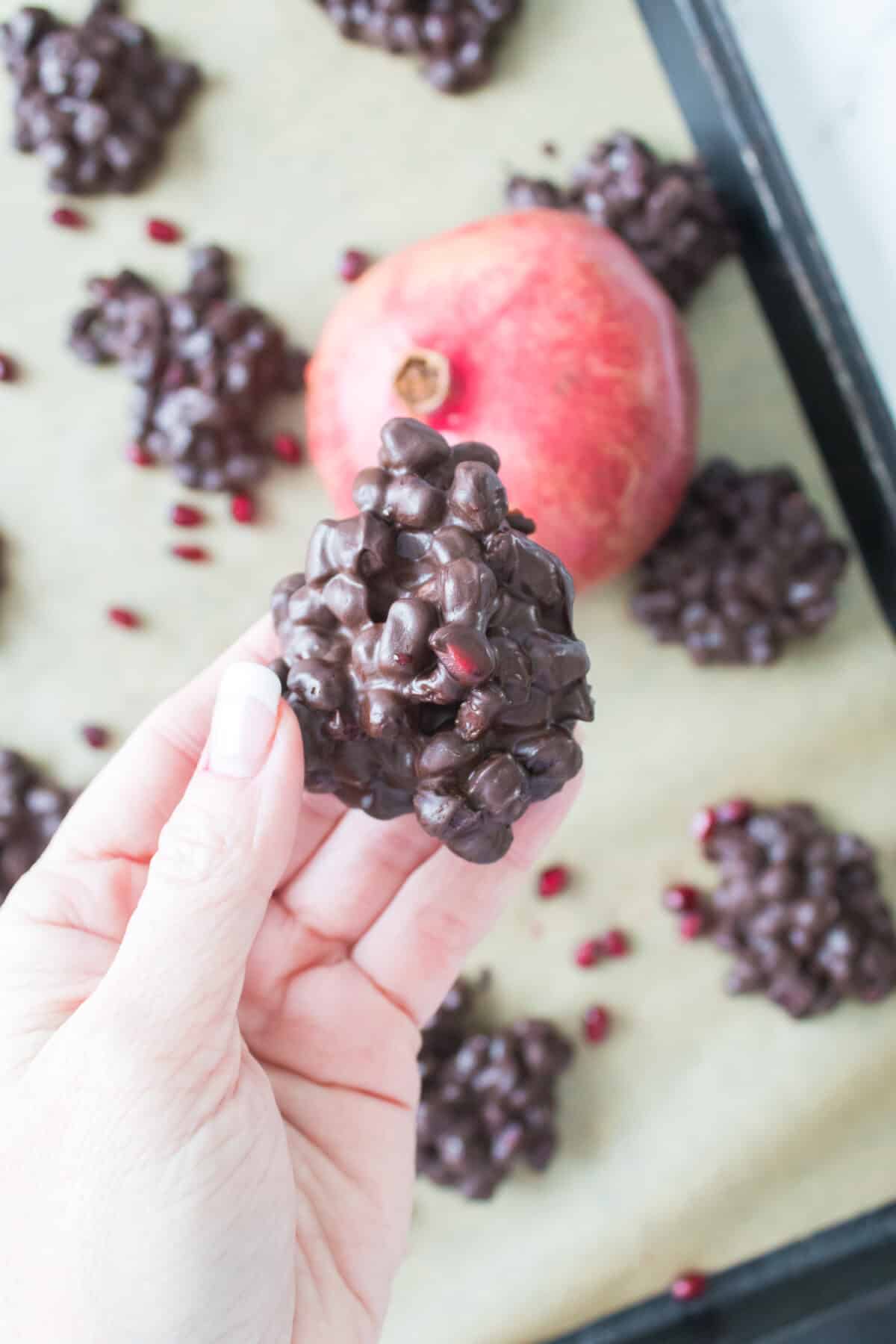 close up of pomegranate chocolate cluster in hand