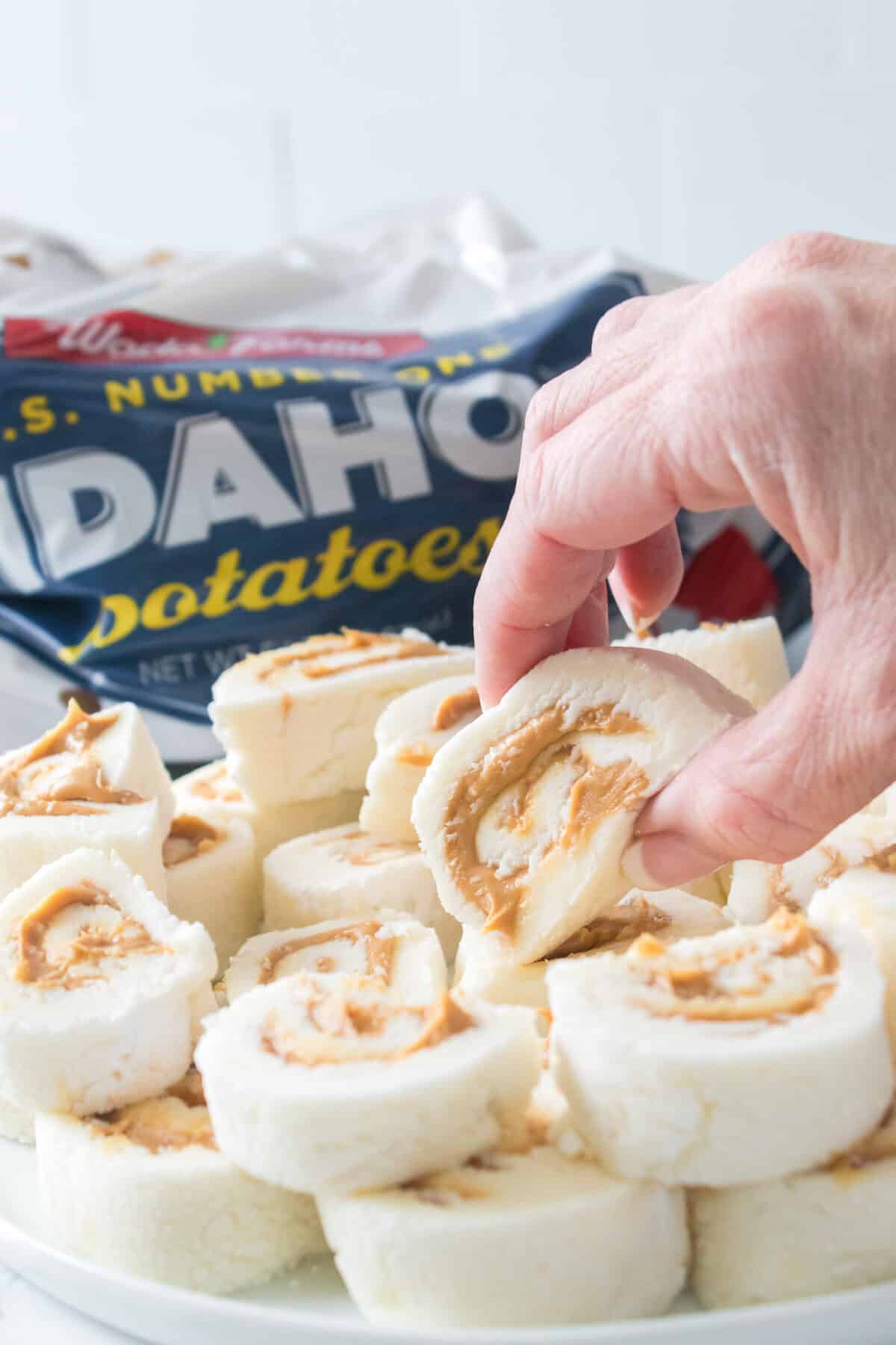 hand grabbing potato candy on a plate