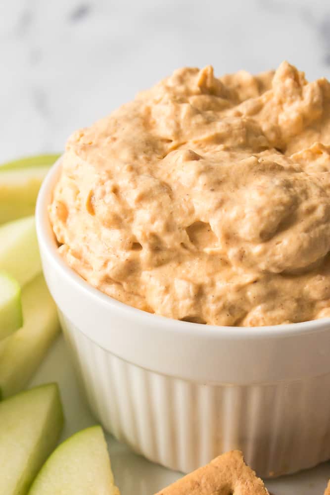 close up vertical shot of pumpkin fluff dip in white serving dish