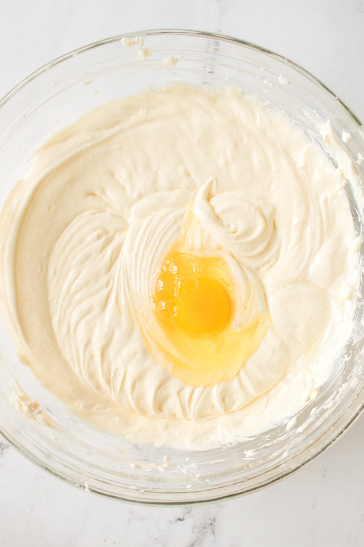 adding egg to cream cheese mixture