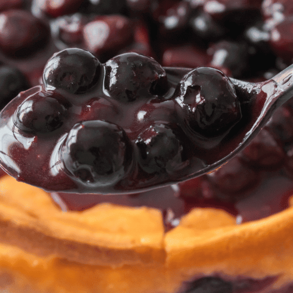 Blueberry Sauce on spoon held over desert