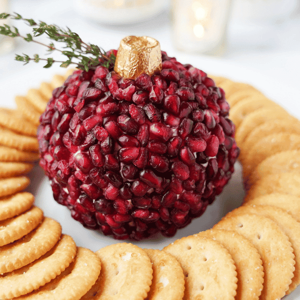 Pomegranate Cheese Ball on plate with crackers on white plate