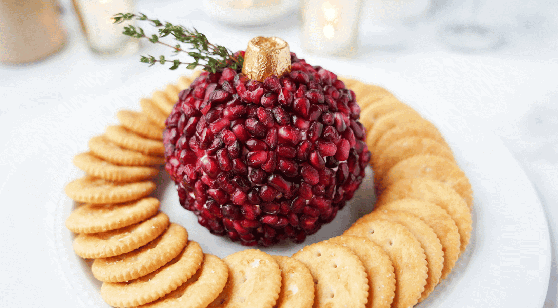 Pomegranate Cheese Ball on plate with crackers on white plate