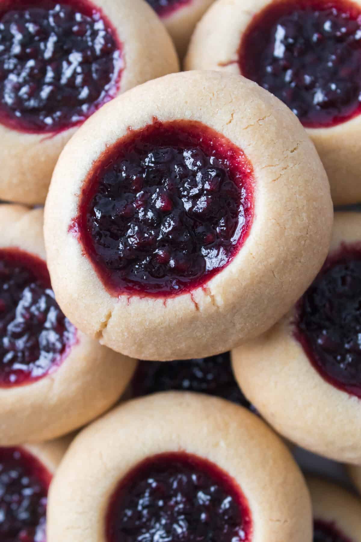 close up vertical shot of thumbprint cookies with homemade blackberry jam