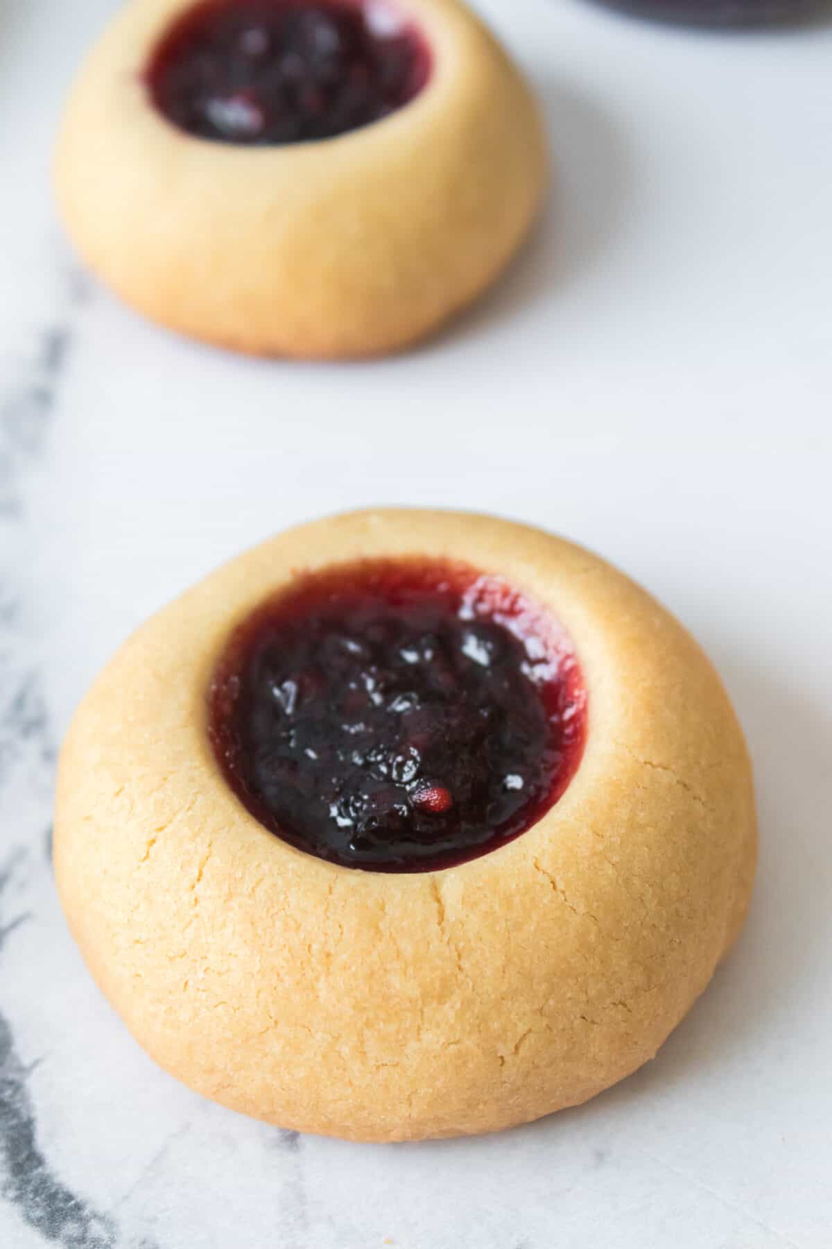 close up shot of thumbprint cookies with blackberry jam