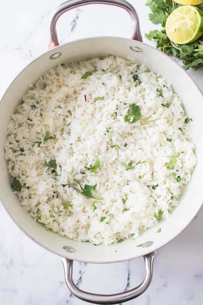 cilantro and lime zest mixed into white rice in pan