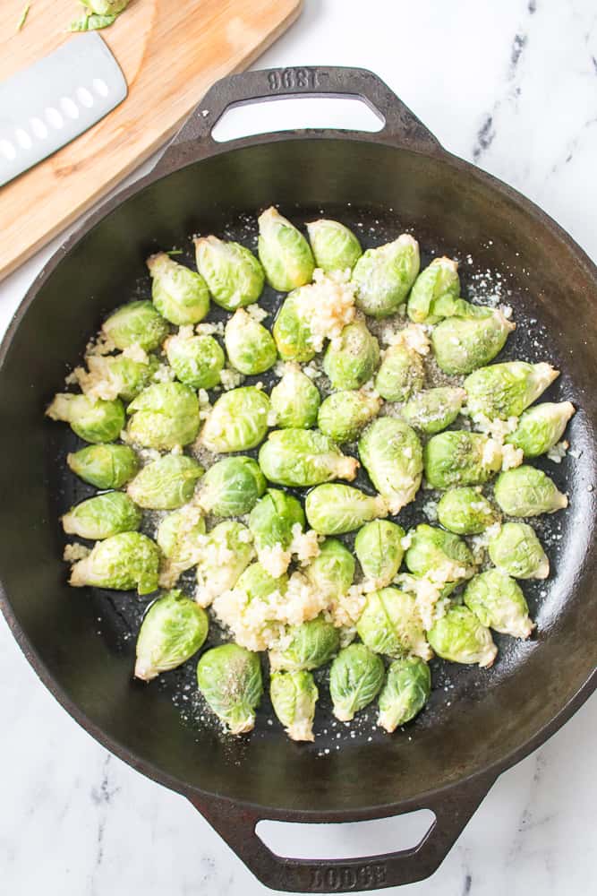brussel spirts with garlic, salt and pepper in cast iron skillet