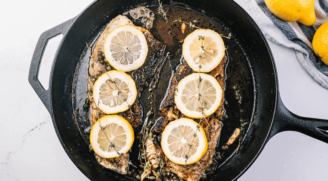 Fish Piccata with lemons in cast iron skillet