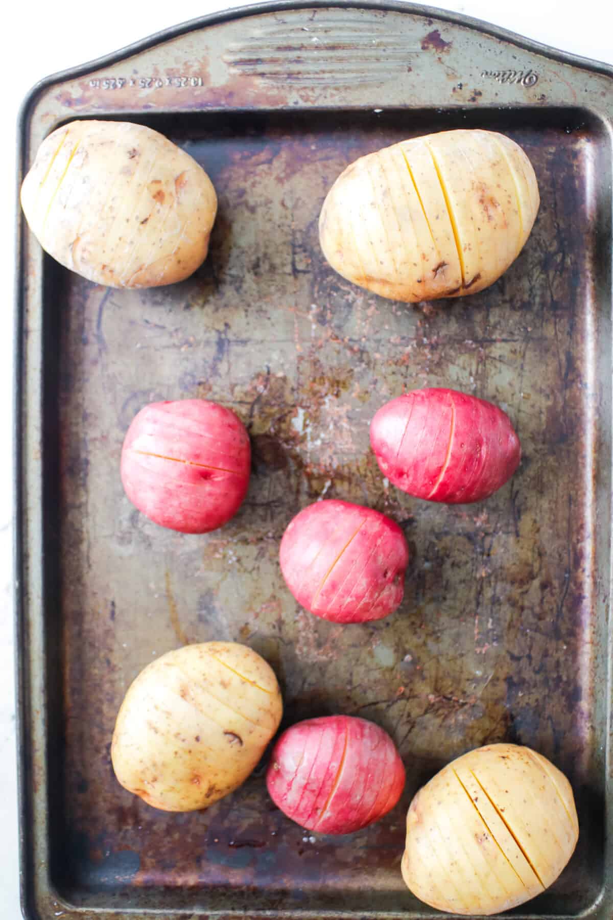 sliced gold and red potatoes on baking sheet