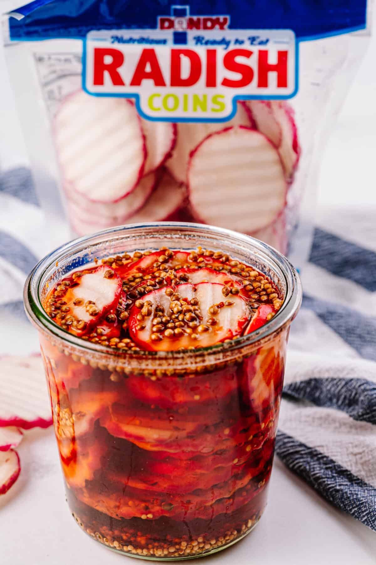 close up shot of pickled radishes in glass jar