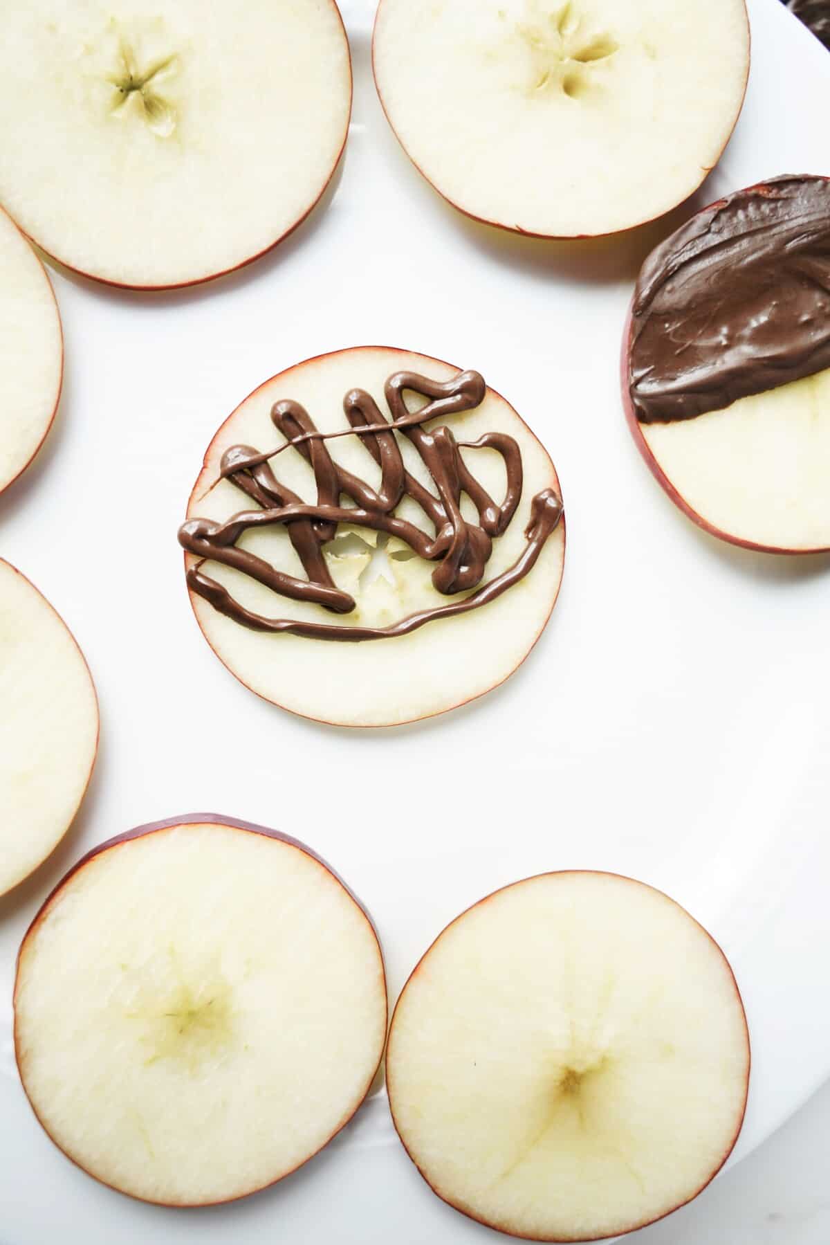 Chocolate piped onto an apples slice.