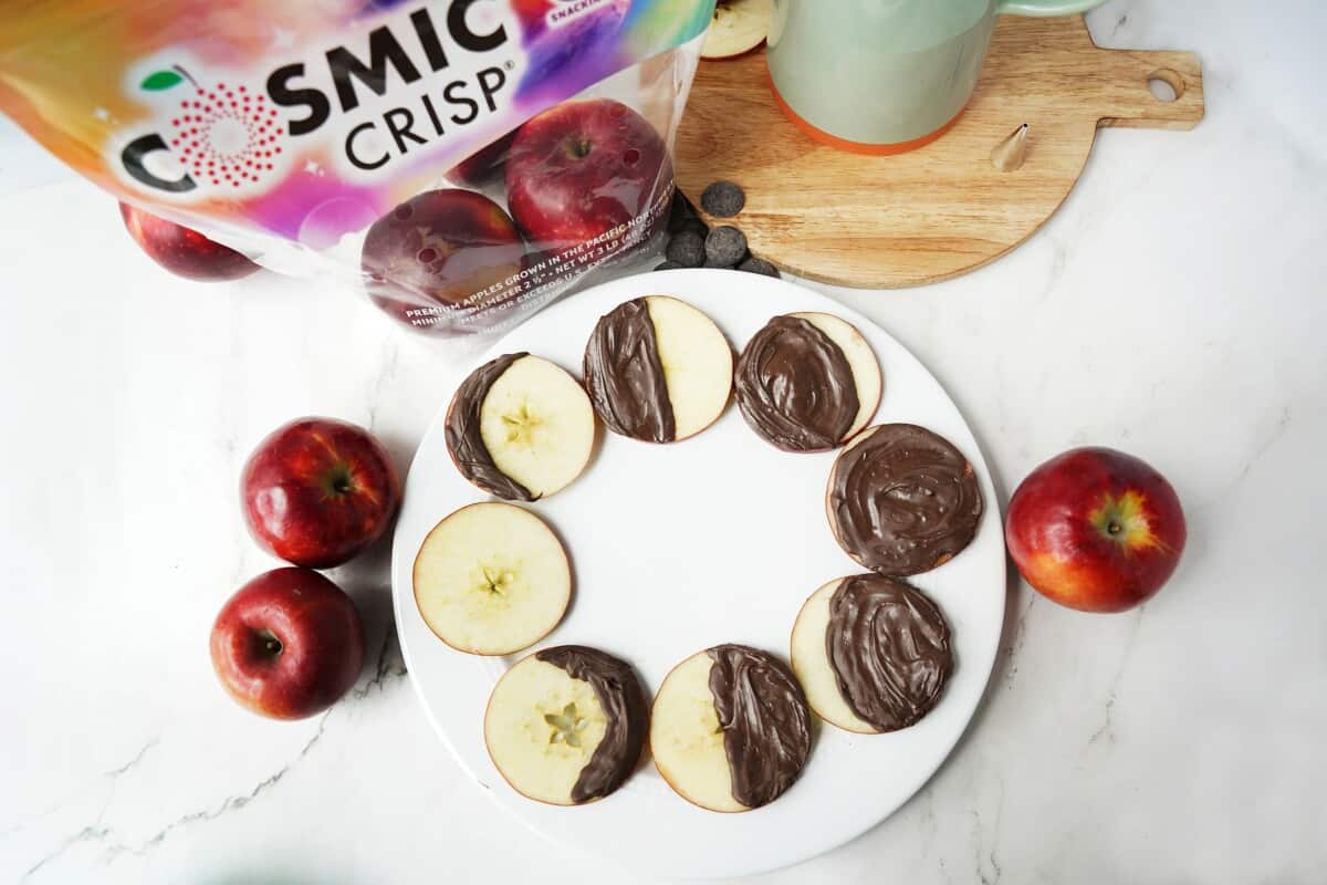 Sliced apples with moon phases made from melted chocolate.