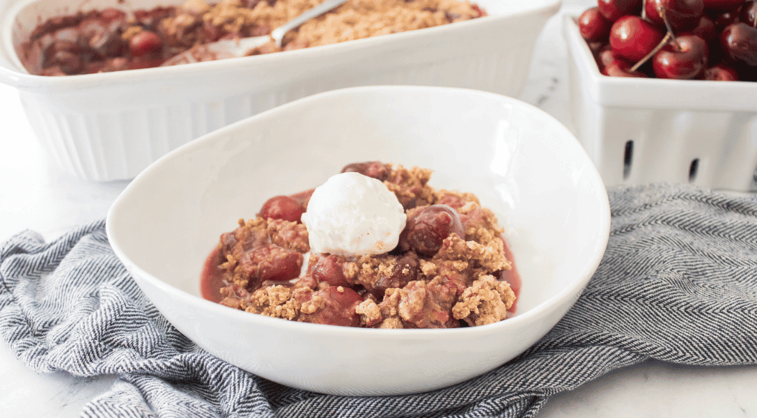 Gluten-Freeh Cherry Cobbler in bowl with cobbler and cherries in background