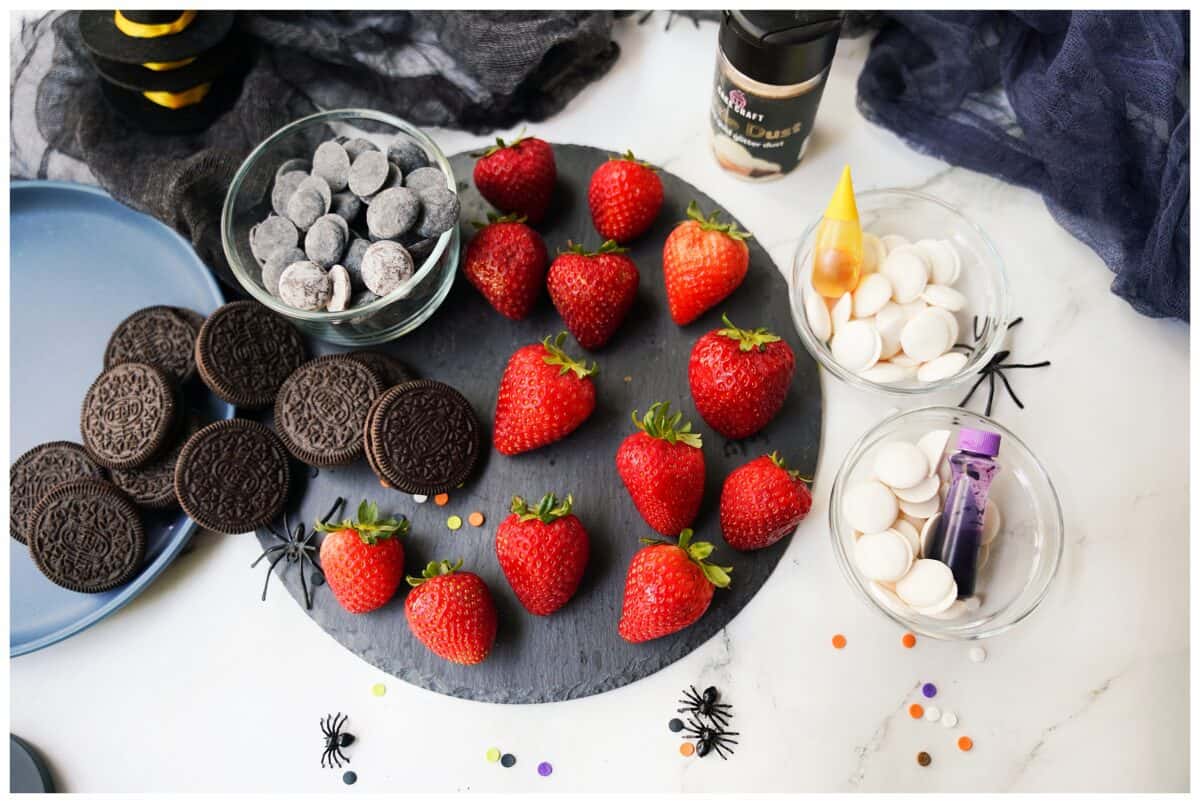 strawberries on cutting board after being dried with oreos, black candy melts, white candy melts