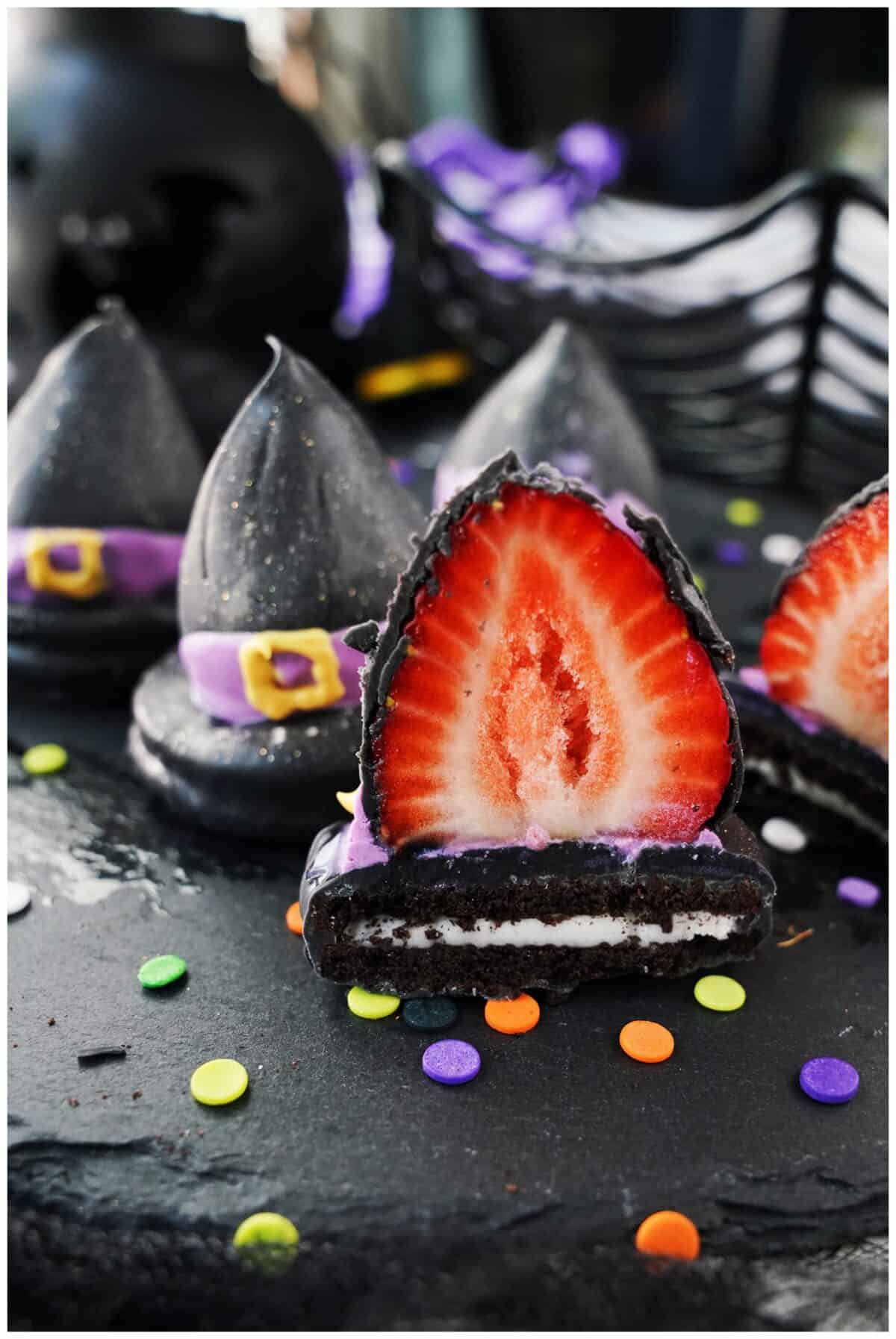 vertical close up shot of chocolate covered strawberry on top of oreo cut open to show strawberry and oreo inside