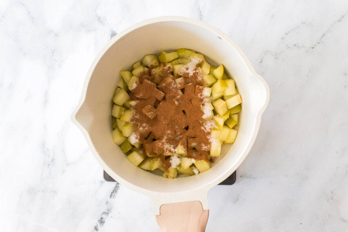sauce pan with diced granny smith apples, cinnamon and sugar