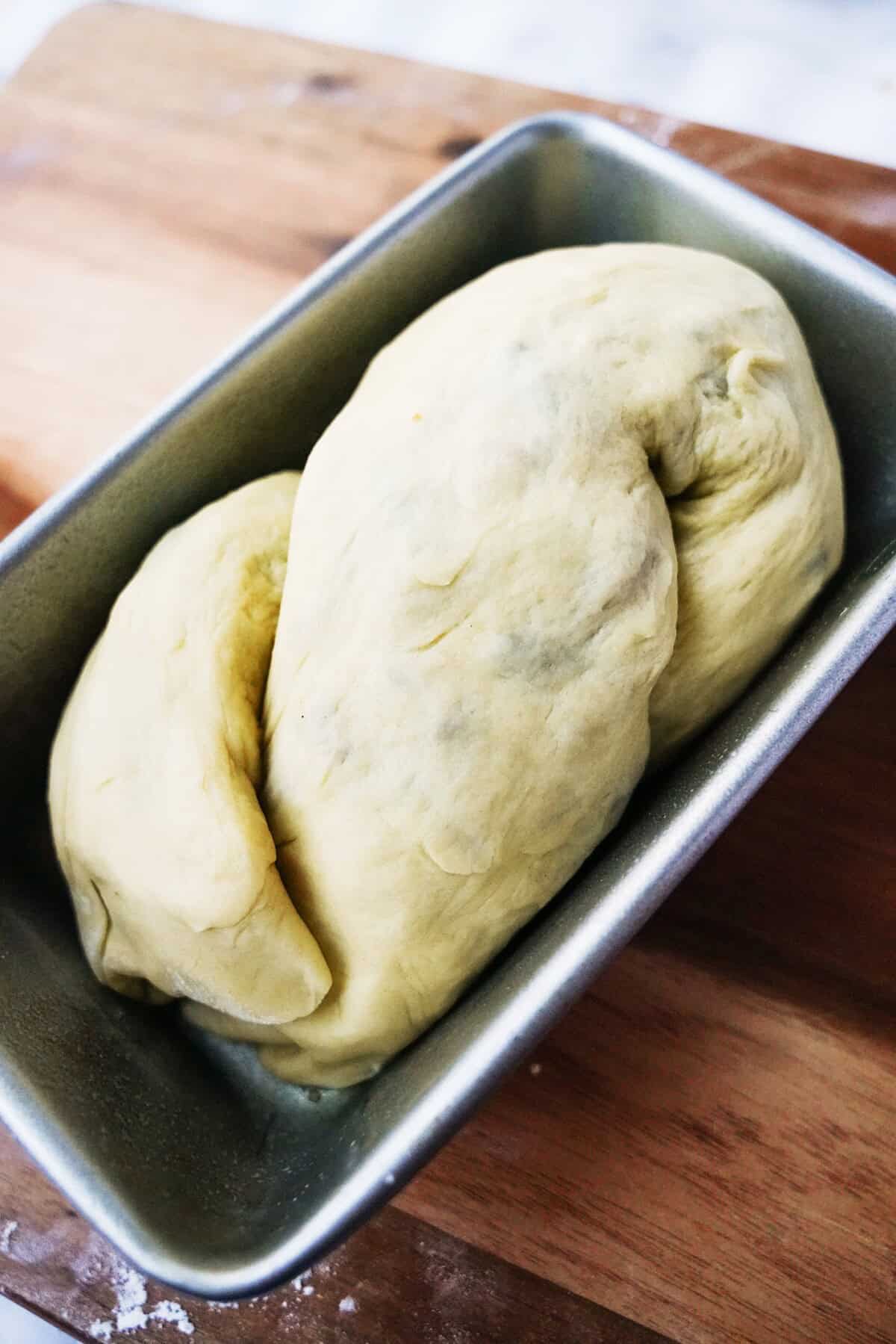 Make a figure 8 with the dough and place it in the loaf pan.