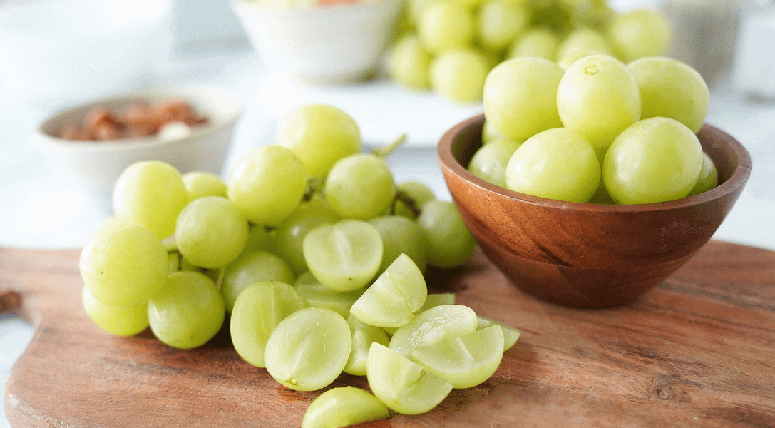 Green grapes in bowl and on cutting board