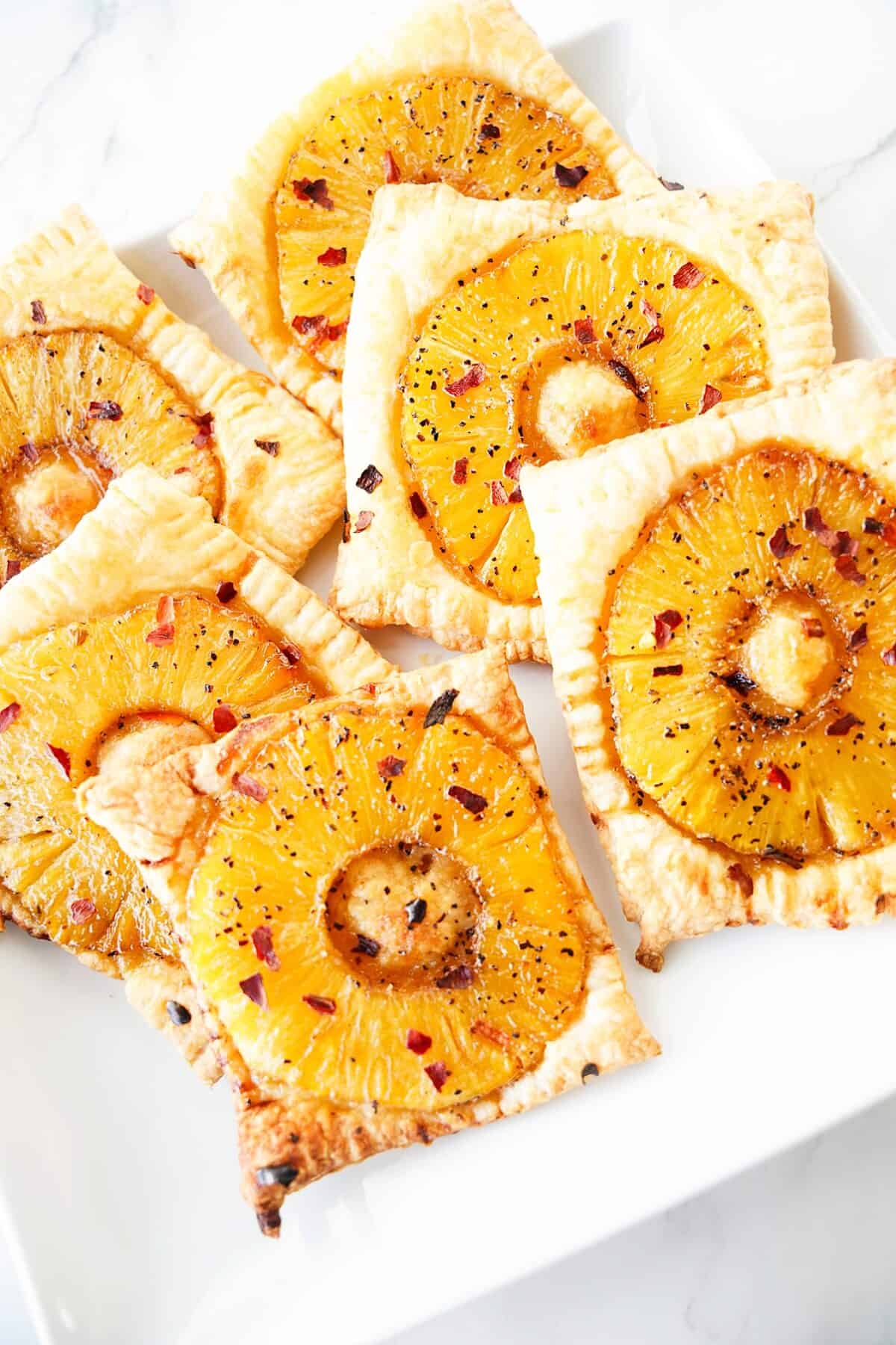 close up vertical shot of spicy pineapple tarts on white plate