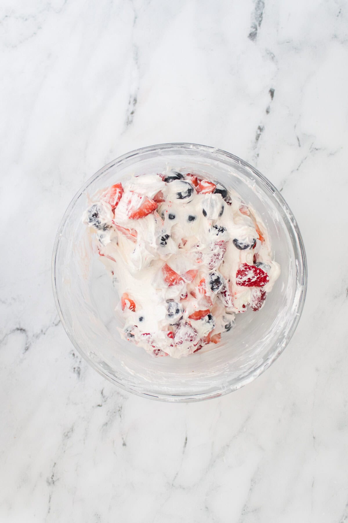 overhead shot of cheesecake fruit salad after berries have been folded in