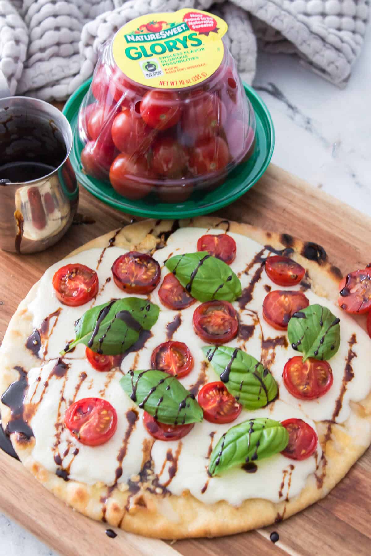 45 degree shot of caprese pizza drizzled with balsamic glaze