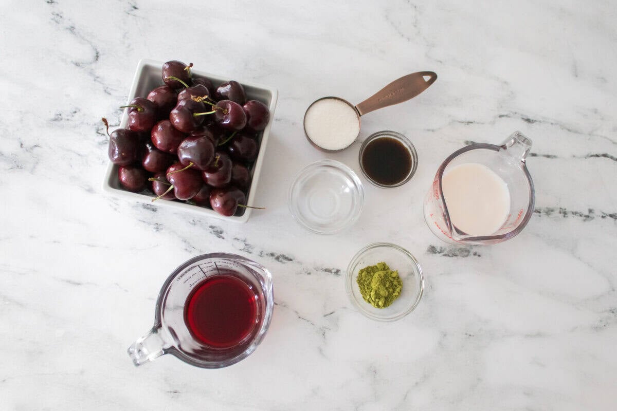 overhead shot of ingredients to make an iced vanilla cherry matcha latte