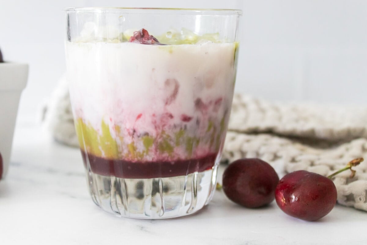 head on shot of layers of cherry syrup, milk and matcha