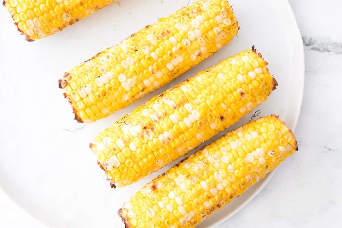 grilled corn on white plate