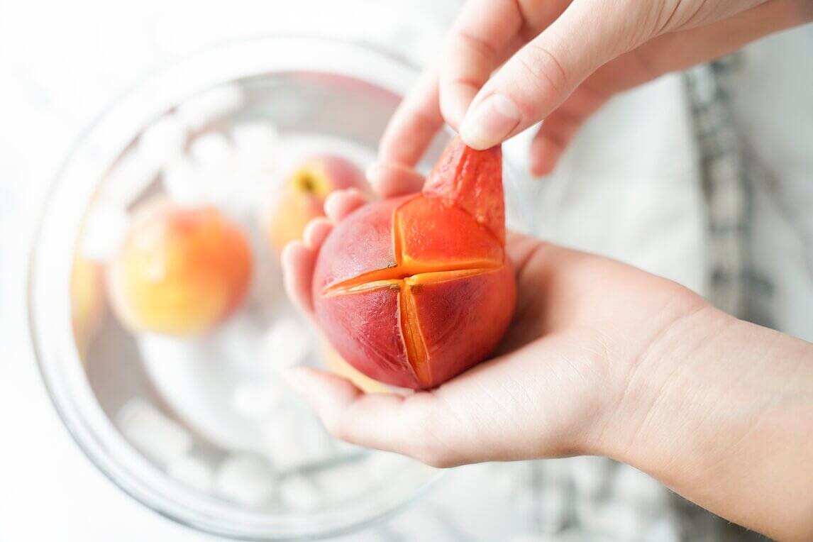 Peeling peach with hand