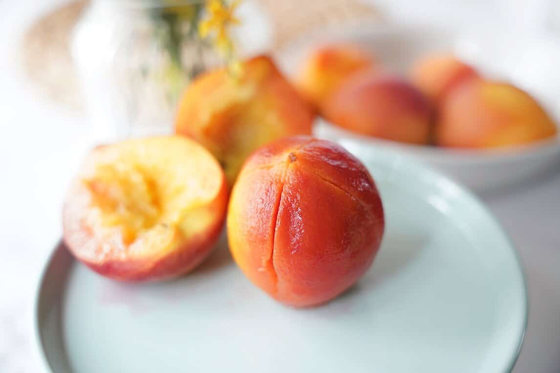 Peeled Peaches on blue plate