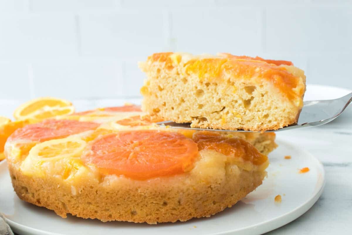slice of a piece of upside down citrus cake being held on a pie spoon to show texture