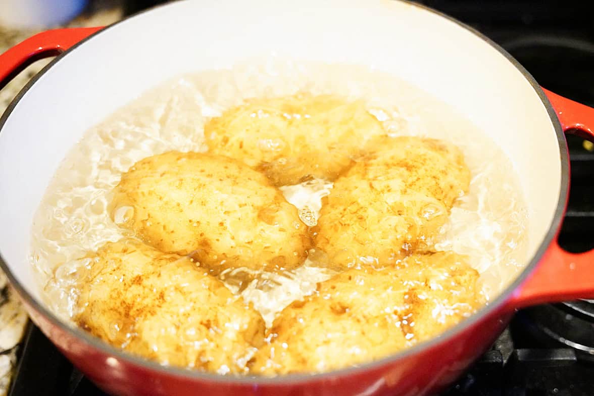 idaho potatoes boiling on stove in red dutch oven