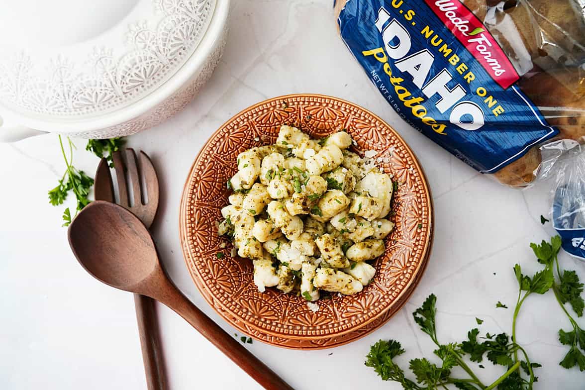 overhead shot of potato gnocchi in bowl with bag of wada farms idaho potatoes on the side